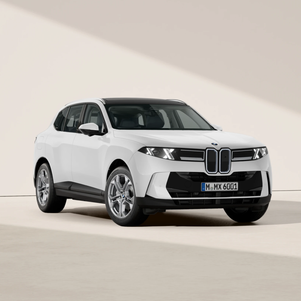 Ein weißer BMW-SUV steht in einem Innenraum auf einem hellen Boden vor einem neutralen, beige-weißen Hintergrund. Das Fahrzeug ist leicht nach links ausgerichtet und präsentiert sein modernes Design sowie den charakteristischen Nierengrill.